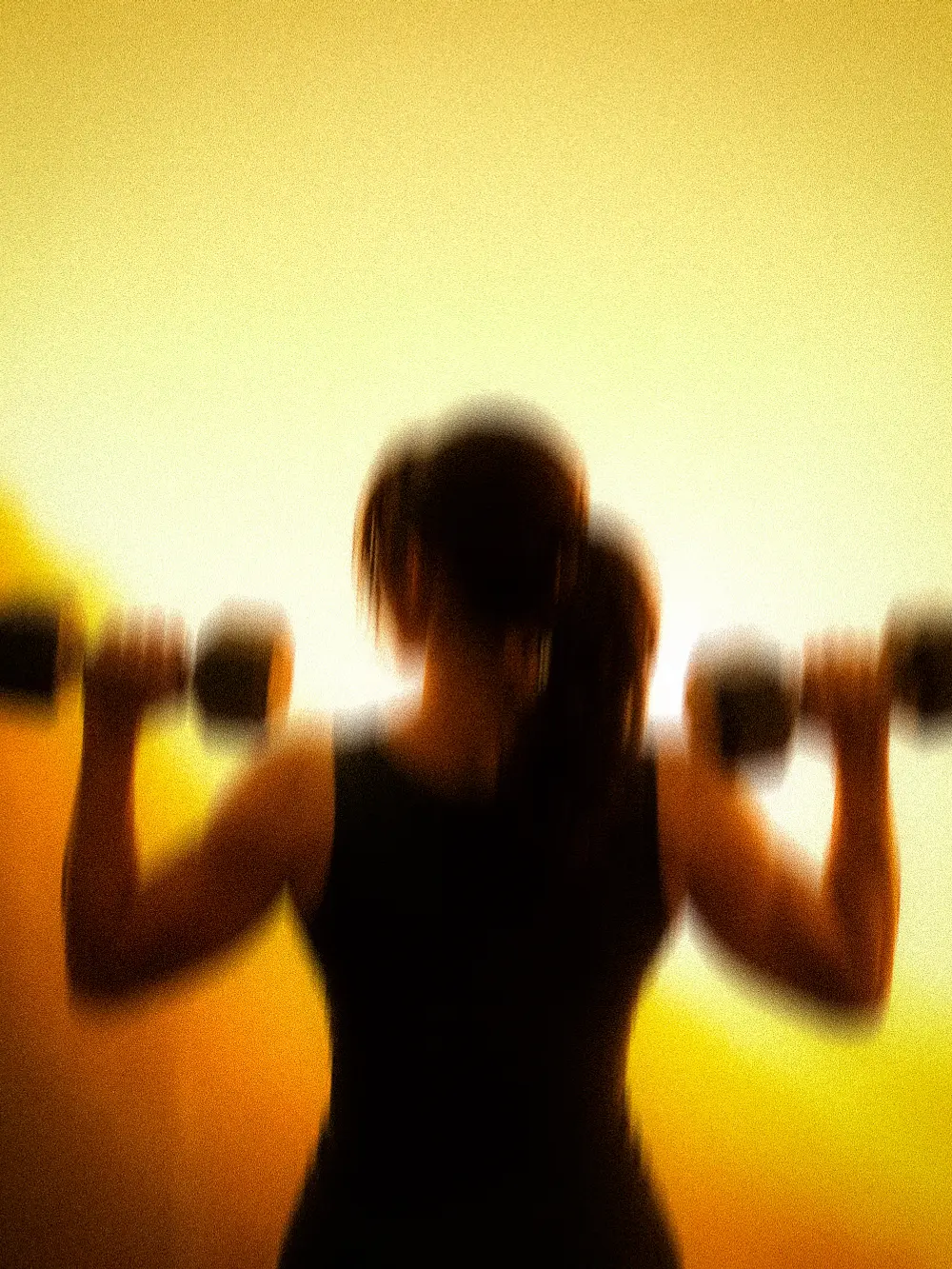 A coach and a member training together in amber light