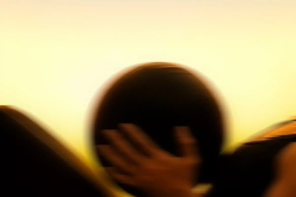A member holding a medicine ball, silhouetted against golden evening light