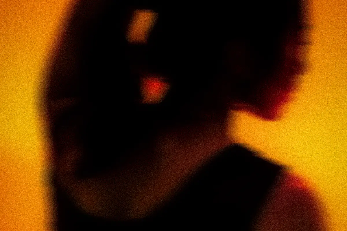 A member stretching an arm overhead against a deep amber wall