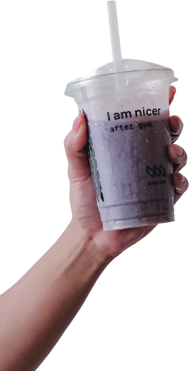 A hand raising a blueberry ASAI GYM smoothie