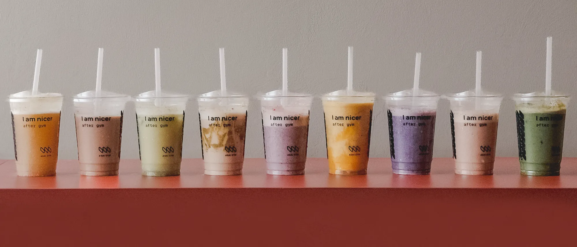 All nine Recharge Bar smoothies in a row on a terracotta bench
