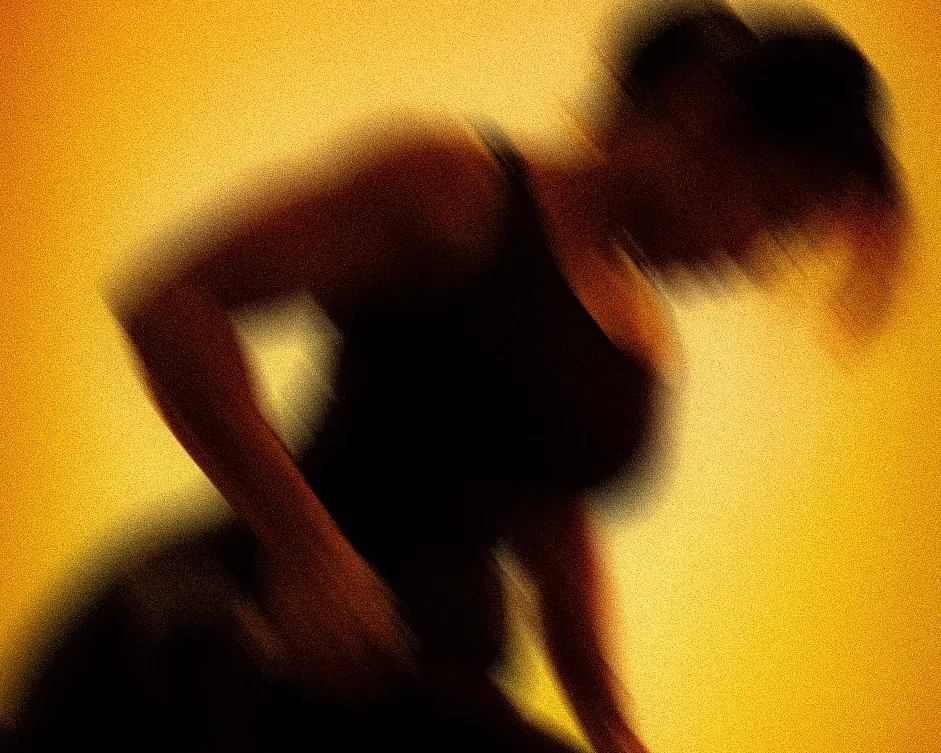 A member mid-movement in silhouette against the amber light of ASAI GYM